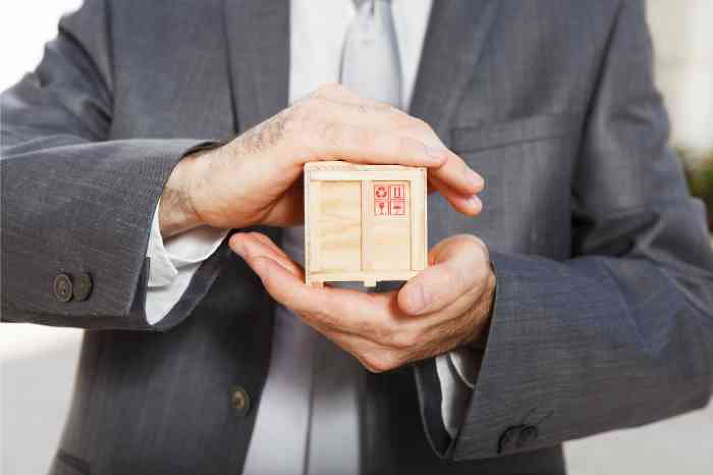 Man holding miniture wooden crate in his hands